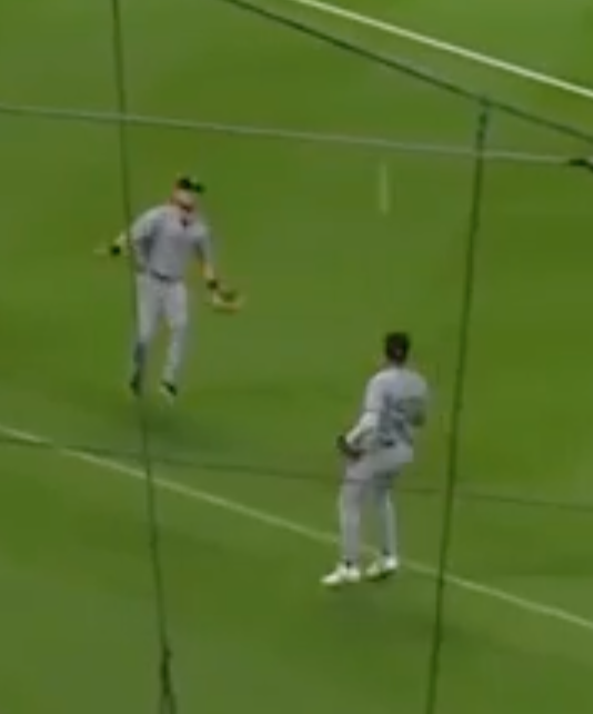 Freeze-frame of two baseball players watching a pop fly drop between them with neither one catching it